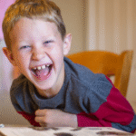 image of family laughing while learning with the Eclectic Home Education Method from AriseHomeEducation.com