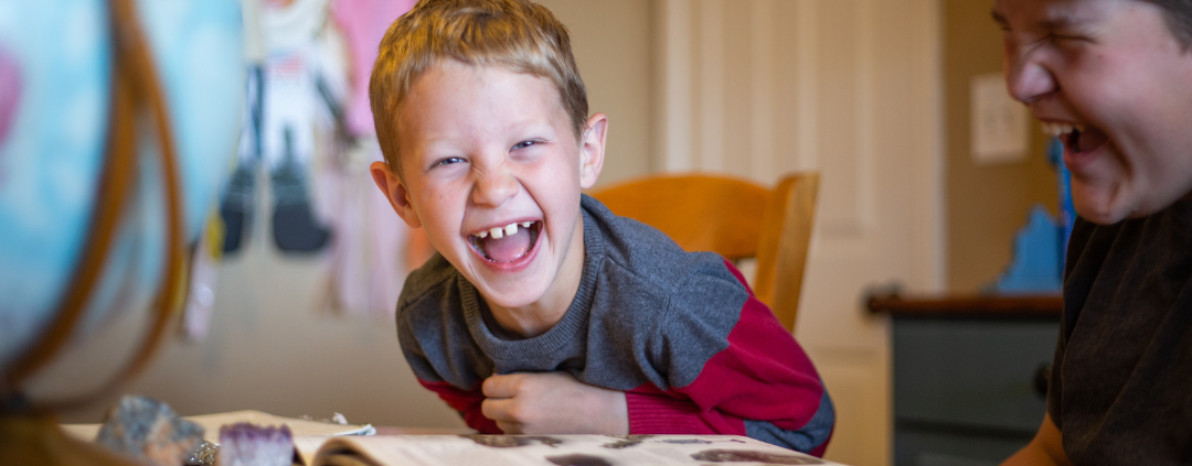 image of family laughing while learning with the Eclectic Home Education Method from AriseHomeEducation.com